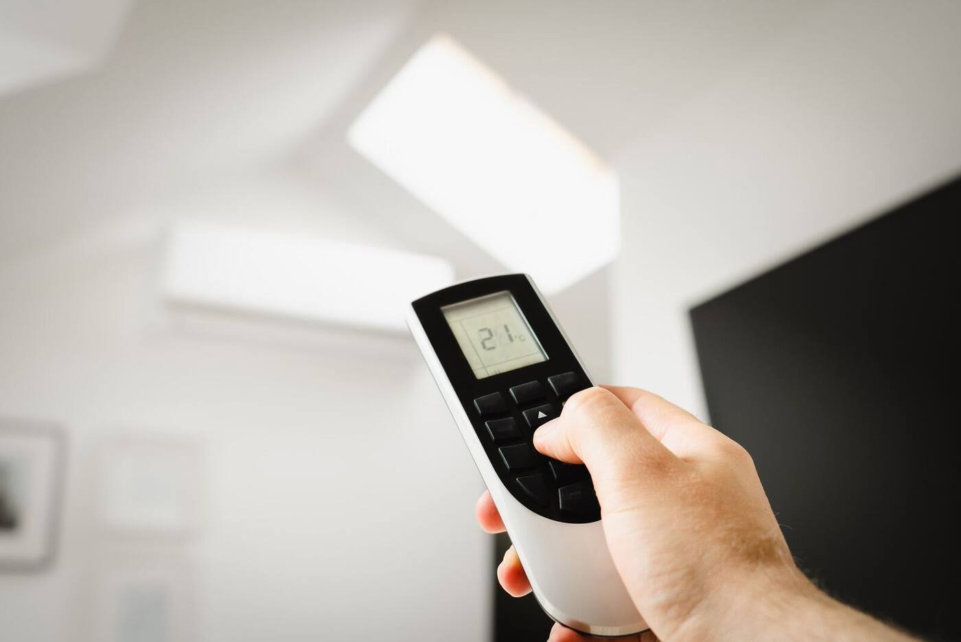 Wall-mounted air conditioning unit being controlled by remote